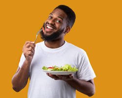 person smiling and enjoying a healthy meal